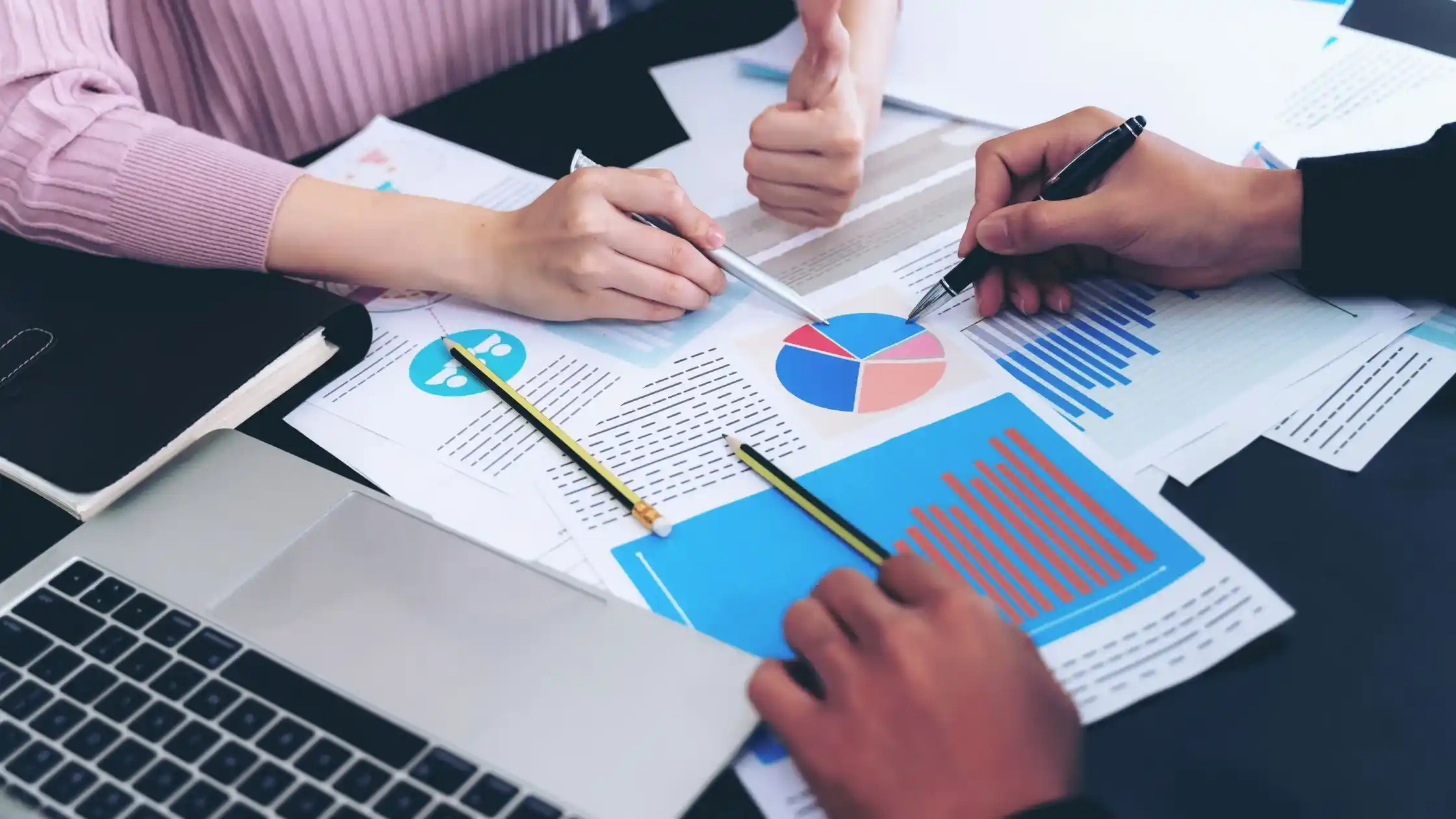 Business professionals reviewing financial reports, charts, and performance analytics during an audit and financial planning meeting.